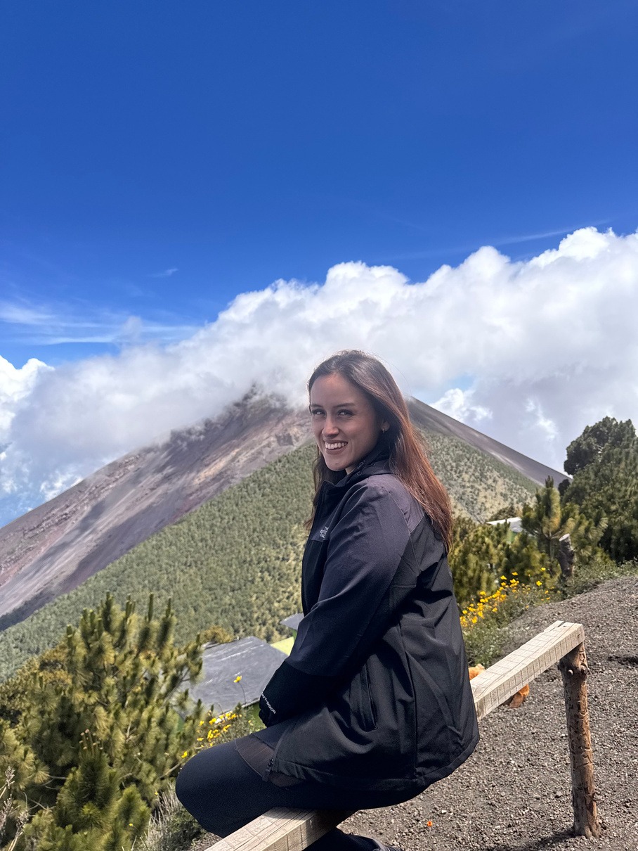 Liz durante un viaje frente a un paisaje montañoso